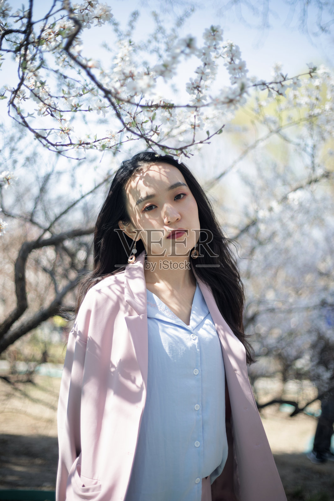 一位美丽的女性在樱花盛开的公园中享受自然生活照片摄影图片