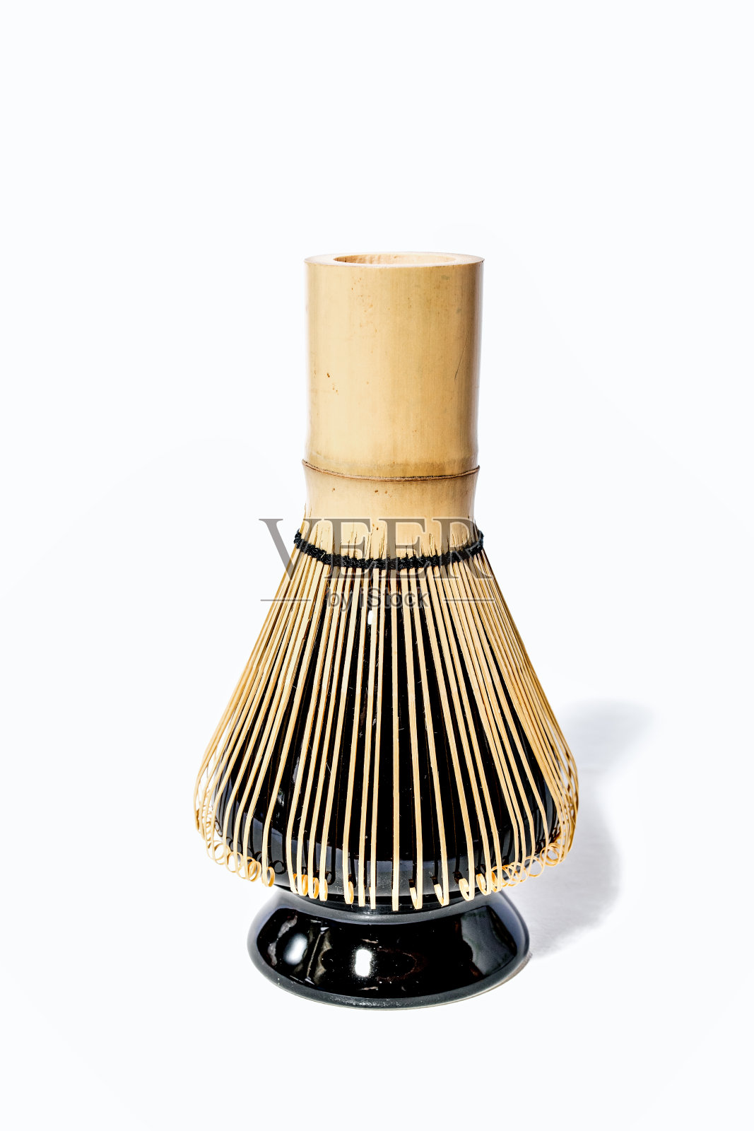 黑色陶瓷支架上的竹制抹茶 whisk，孤立在白色背景上照片摄影图片