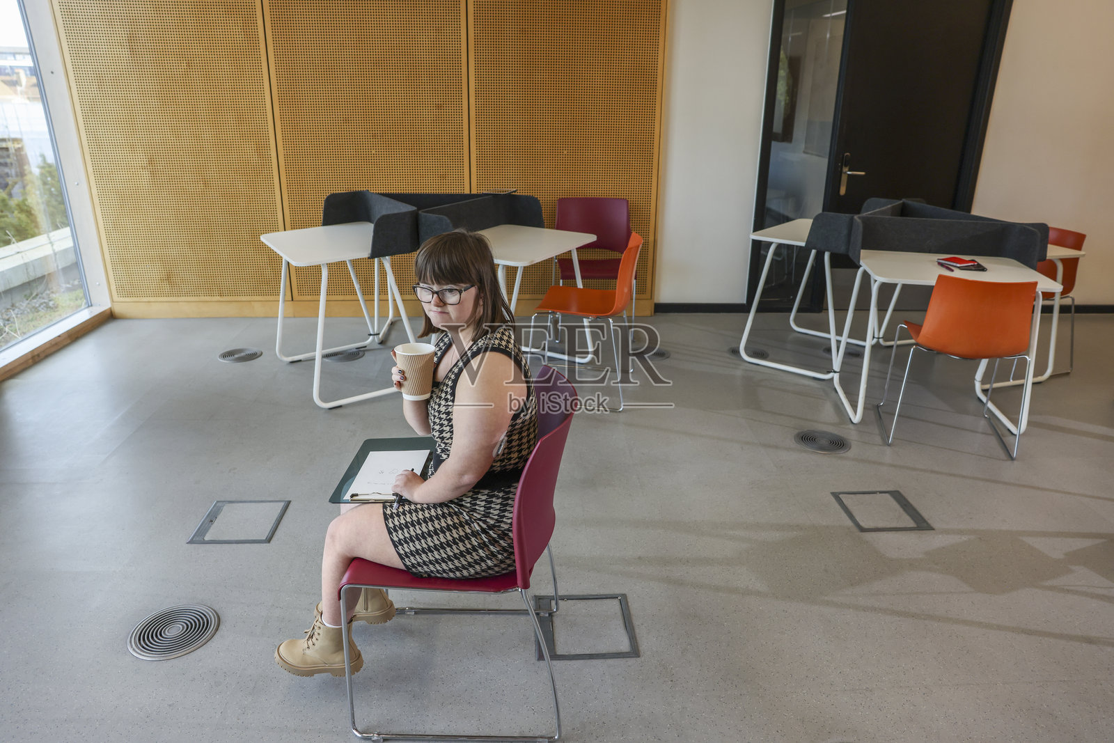 在办公室里坐着的唐氏综合症女性照片摄影图片