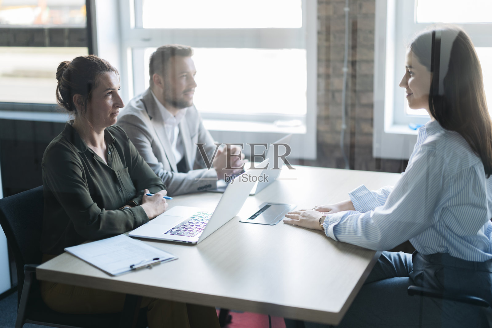 年轻职业女性正在与两位高级经理进行面试照片摄影图片