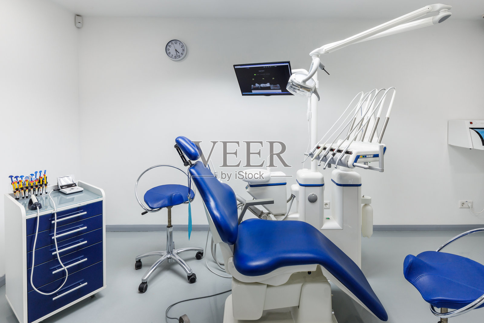 现代牙科诊所内部，配备蓝色设备、治疗椅和先进技术，为患者提供舒适的护理环境，明亮且卫生。照片摄影图片