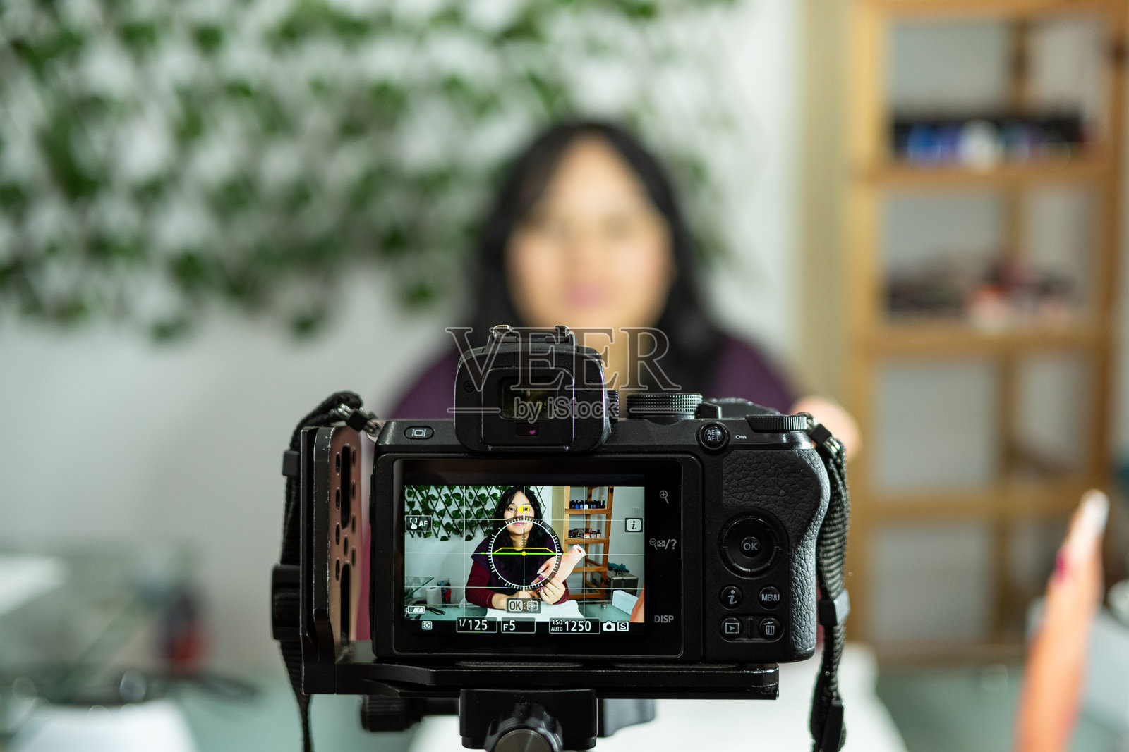 年轻的拉丁裔女性使用专业相机录制视频课程照片摄影图片