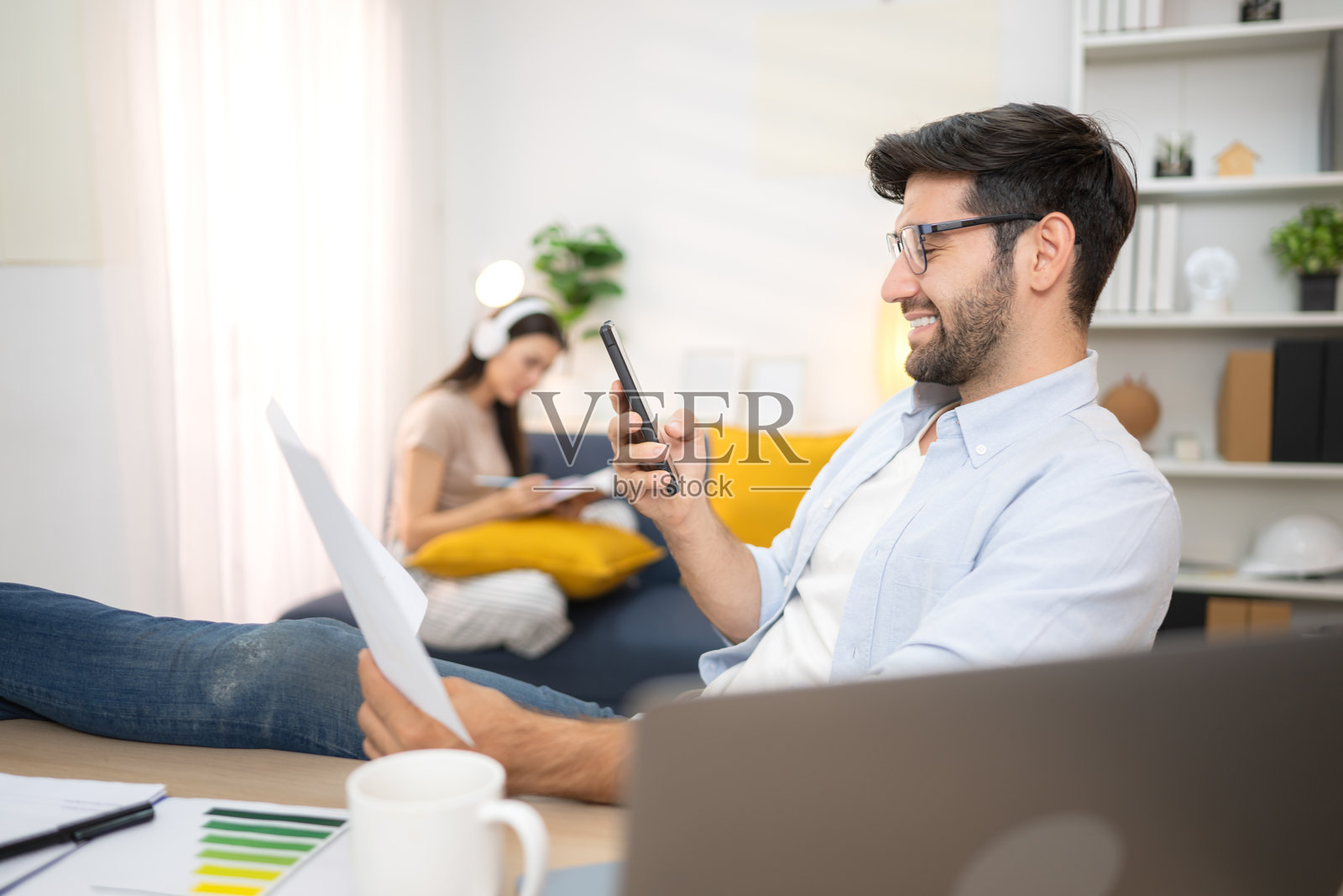 年轻自由职业者在家与女友一起用笔记本电脑在线工作，面带微笑。照片摄影图片