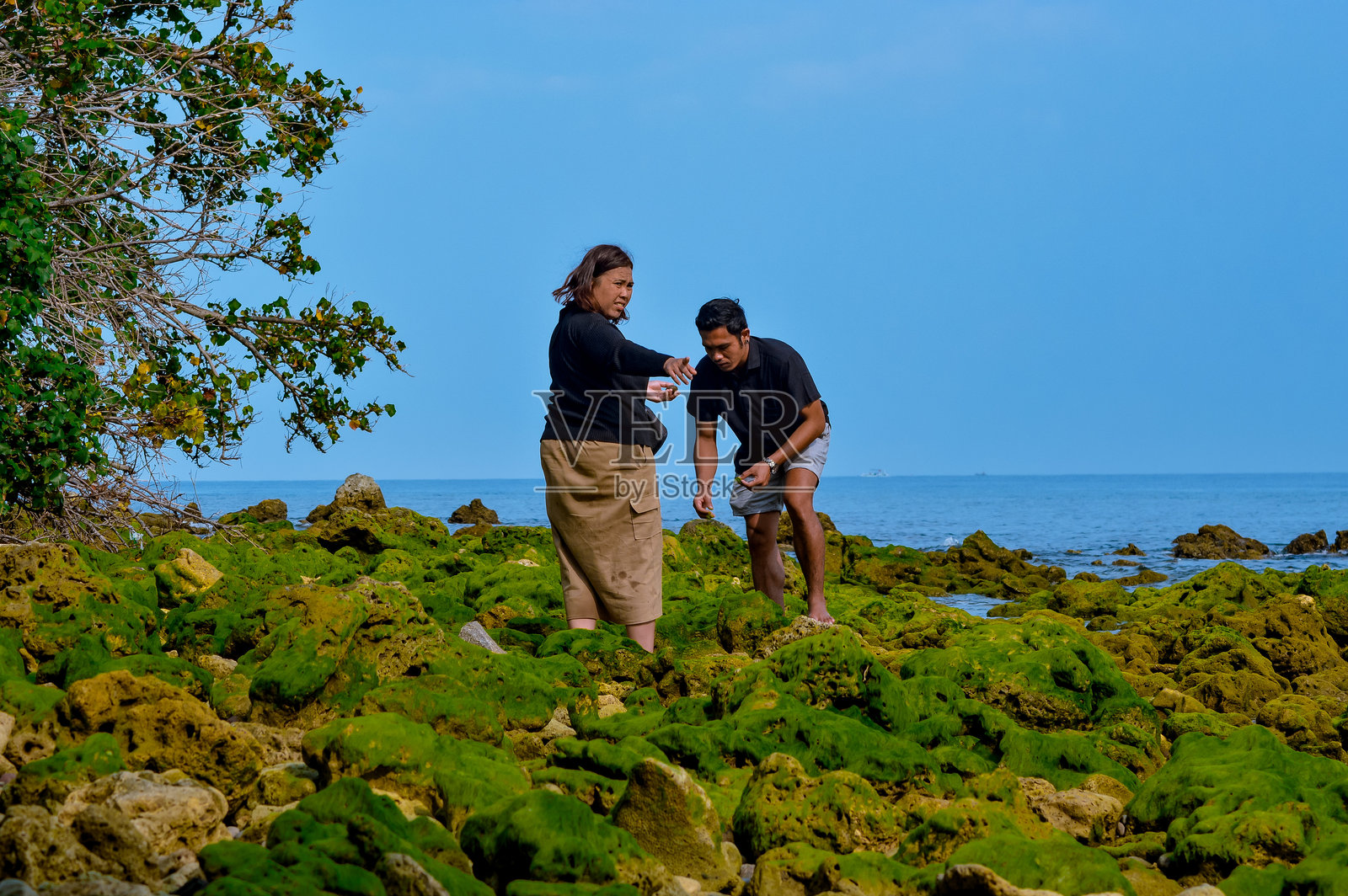 亚洲兄妹在岩石海滩探索照片摄影图片