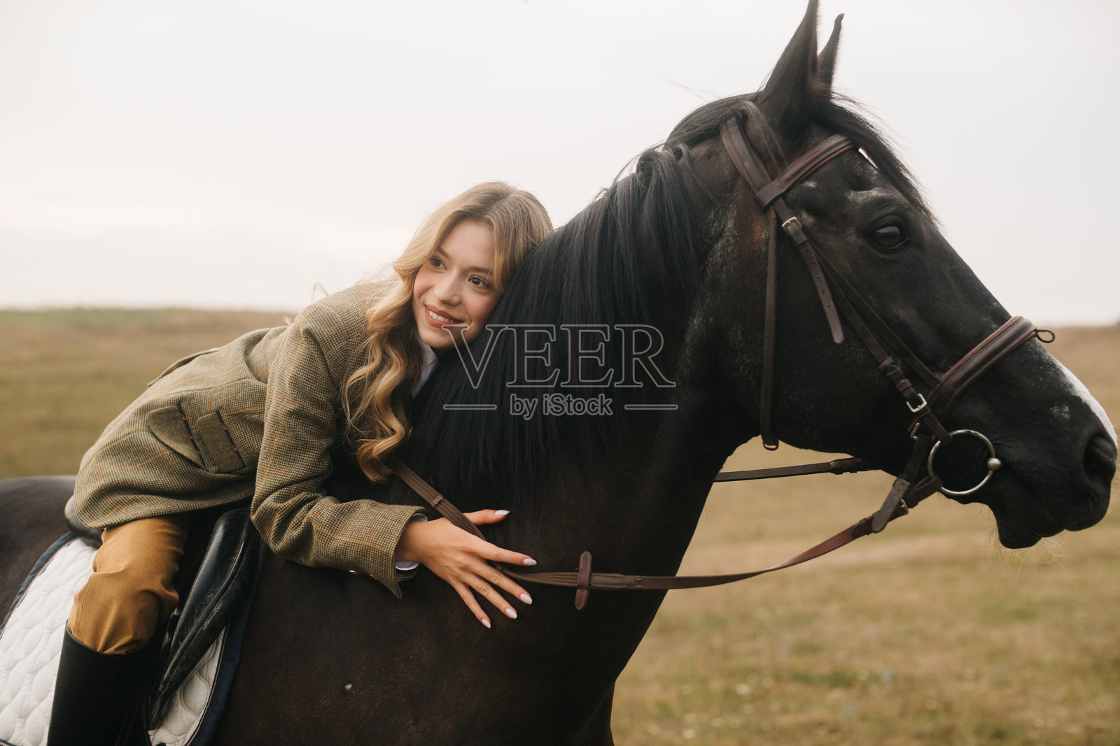 年轻女性在风景如画的户外环境中拥抱一匹黑马照片摄影图片