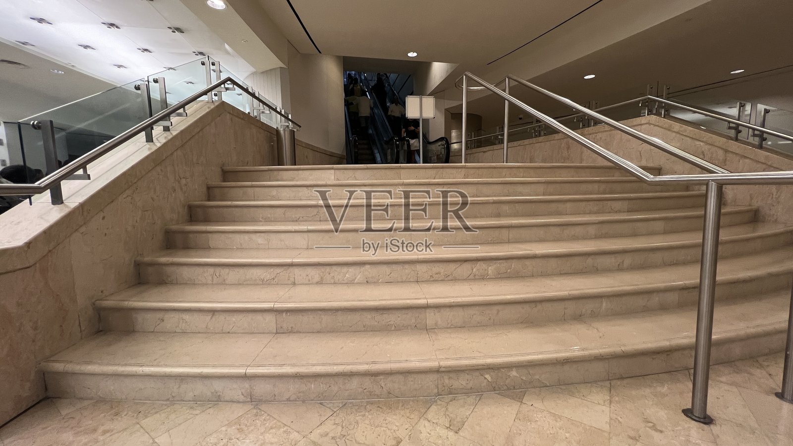 购物中心、机场、地下室、办公室、地铁和轻轨站的电动扶梯或移动楼梯。空荡荡的楼梯和扶梯在高架火车站，公共场所的高楼梯。照片摄影图片