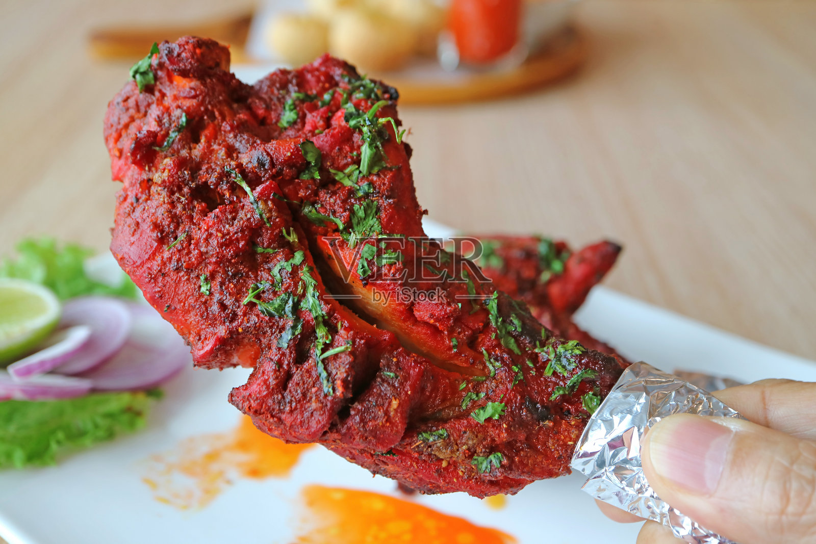 手工挑选一块美味的坦杜里鸡肉照片摄影图片