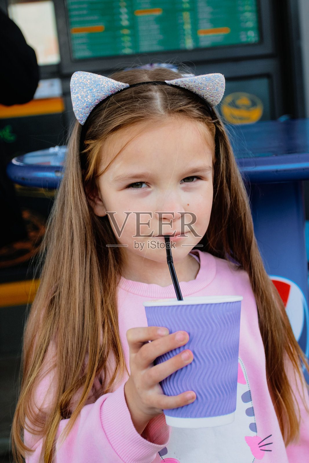 女孩用吸管喝杯子里的饮料照片摄影图片
