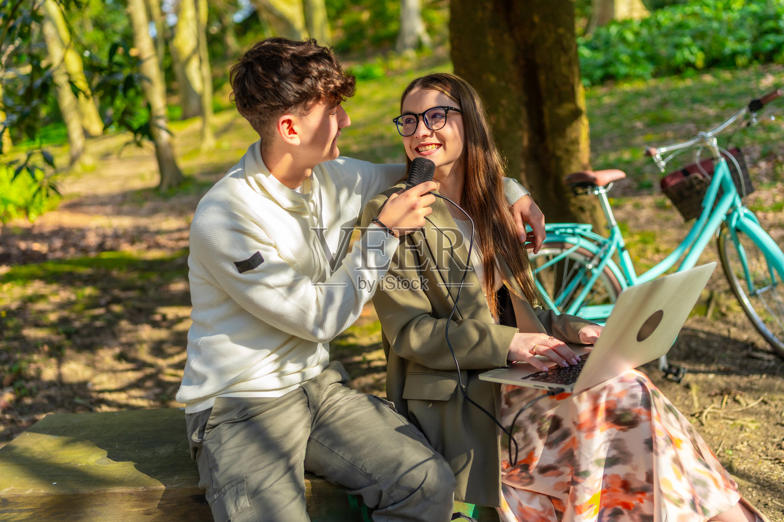 年轻情侣在公园录制播客照片摄影图片