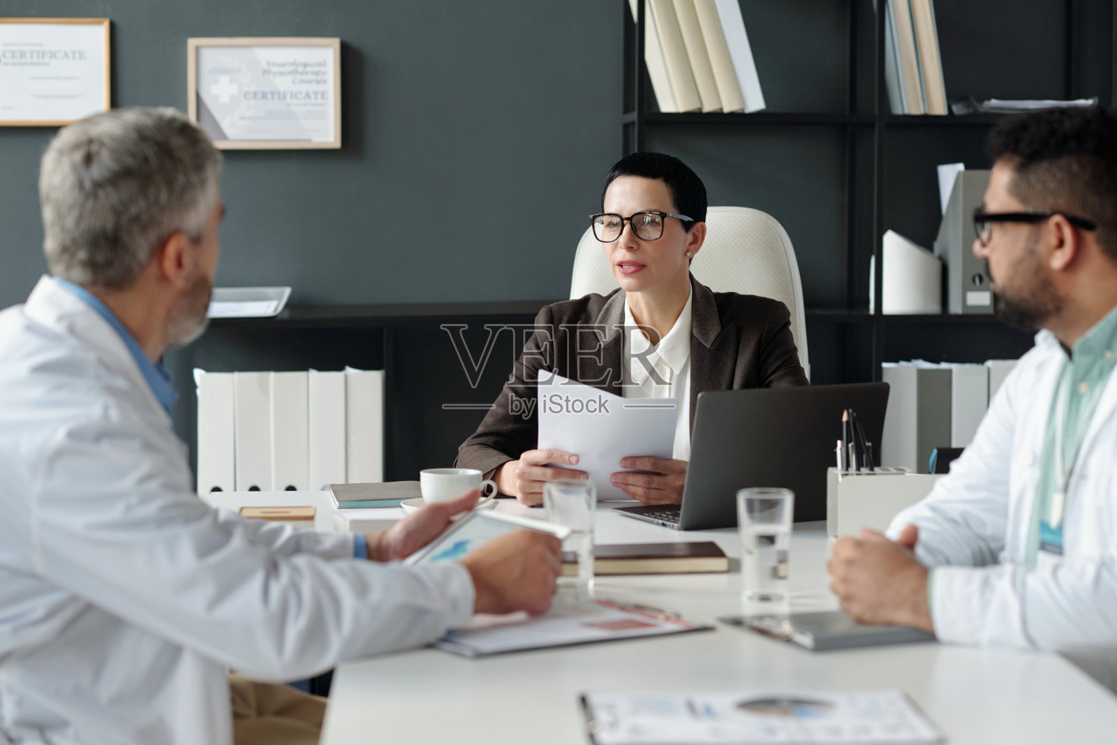 女性老板在诊所的管理会议上与医生们交谈照片摄影图片