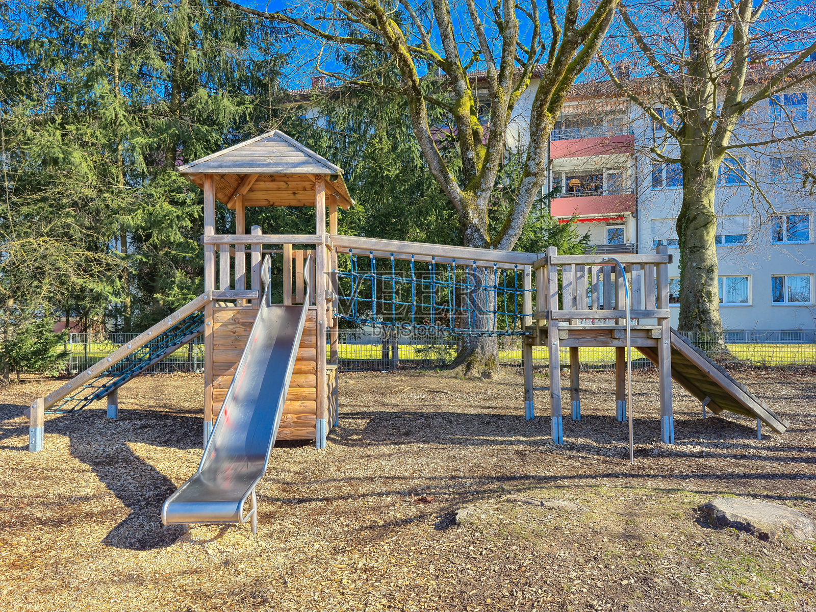 一个儿童游乐场，明亮的蓝色滑梯映衬着湛蓝的天空照片摄影图片