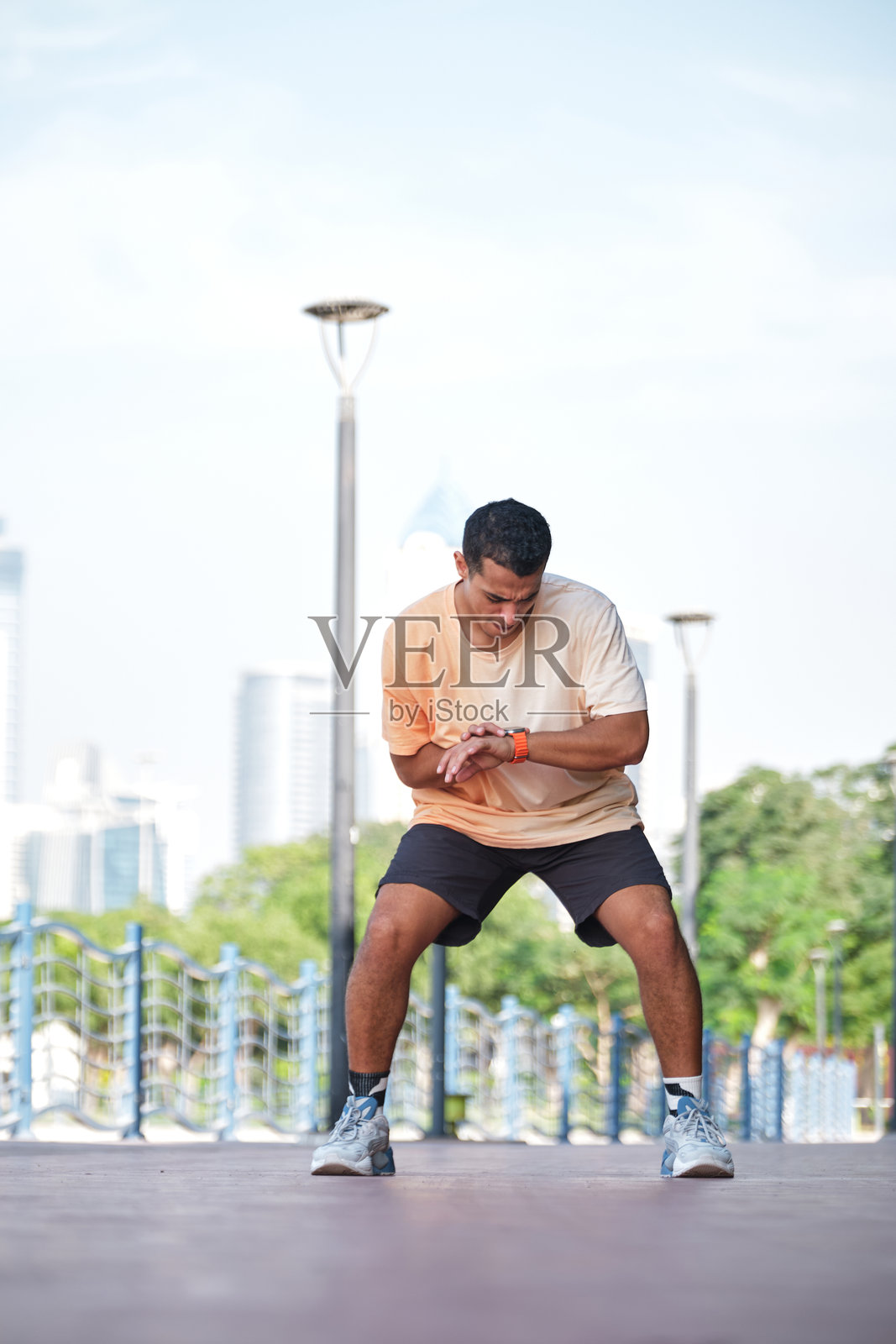 男性运动员在智能手表上启动健身追踪器照片摄影图片