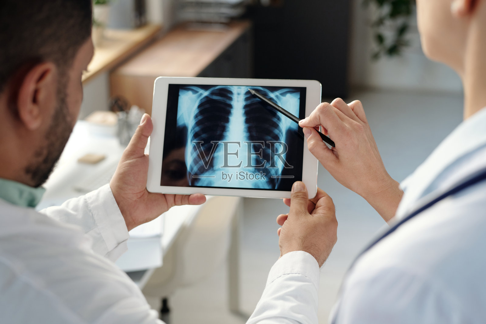 两位医生正在仔细检查胸部X光片的特写镜头照片摄影图片