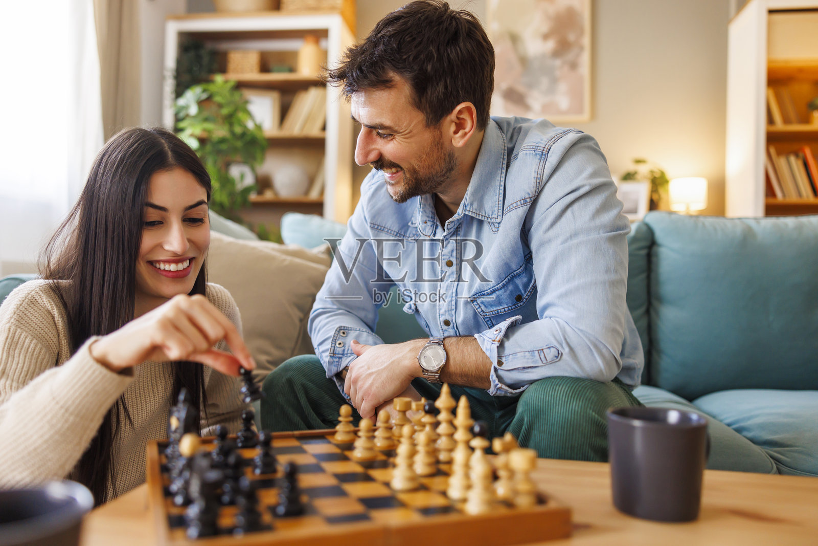 情侣在家中悠闲地下棋照片摄影图片