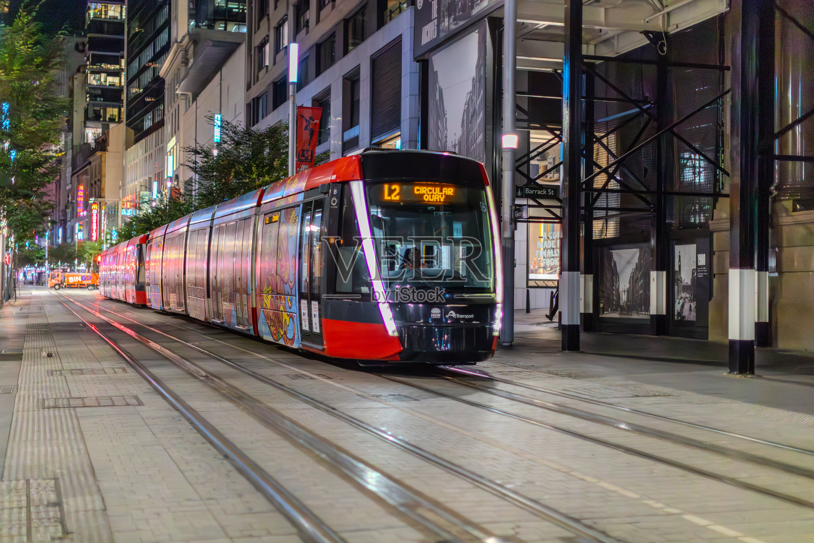 悉尼新南威尔士州乔治街上行驶的电车，蓝色时刻的城市CBD灯光与运动模糊效果。照片摄影图片