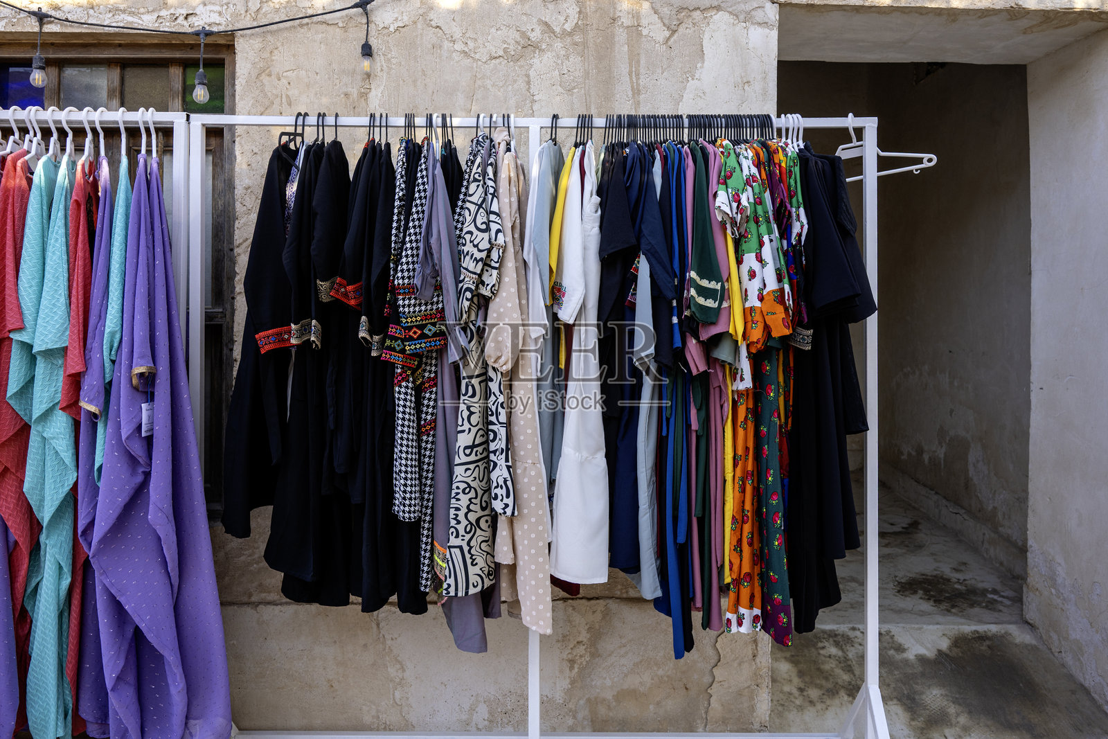 在瓦赫拉市场的一家布料店里，展示着传统阿拉伯长袍和服装供出售。照片摄影图片