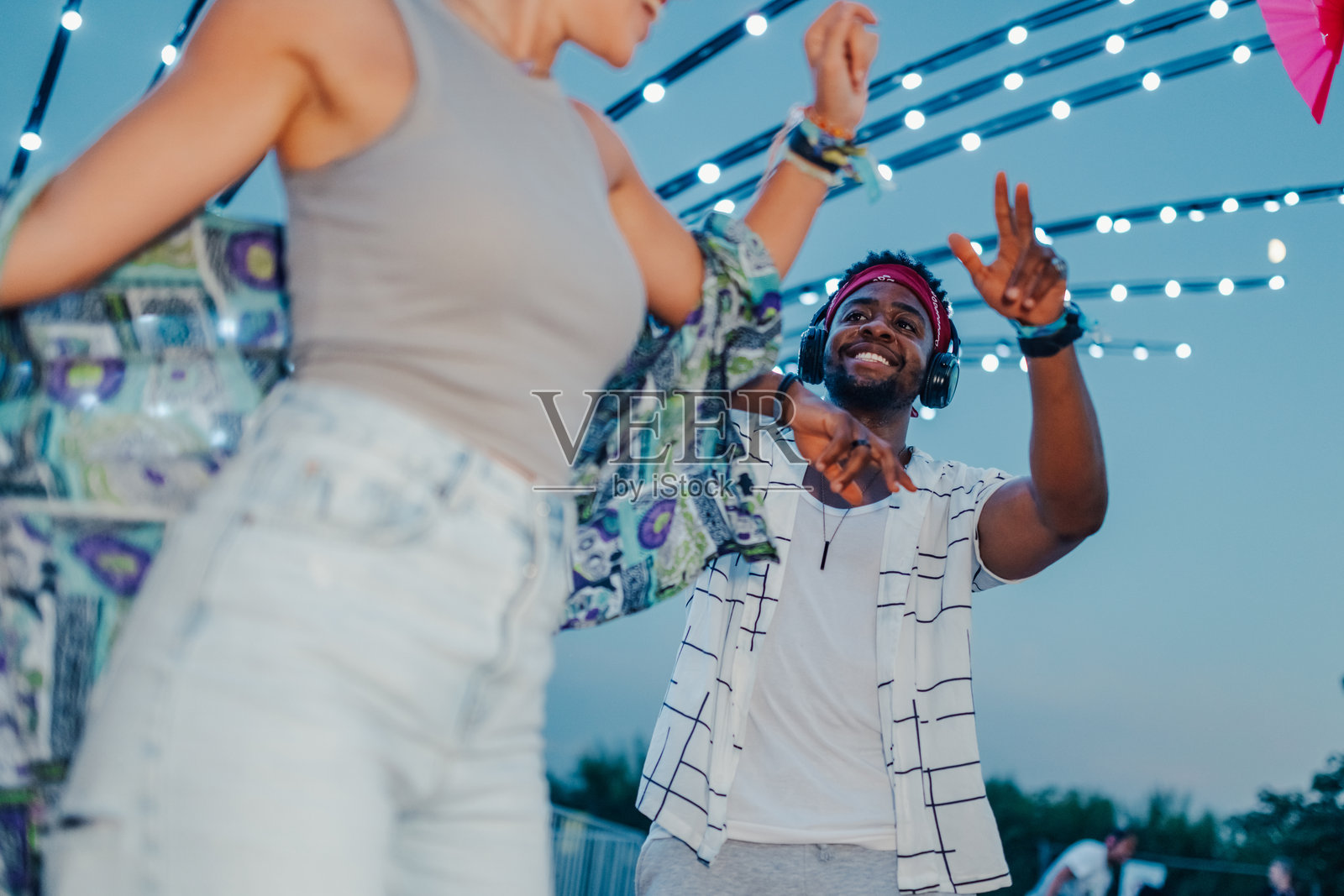 朋友们在串灯下跳舞，享受音乐节的乐趣照片摄影图片