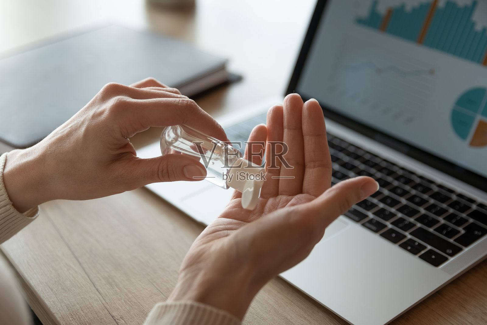 女性员工在工作场所用洗手液清洁双手照片摄影图片