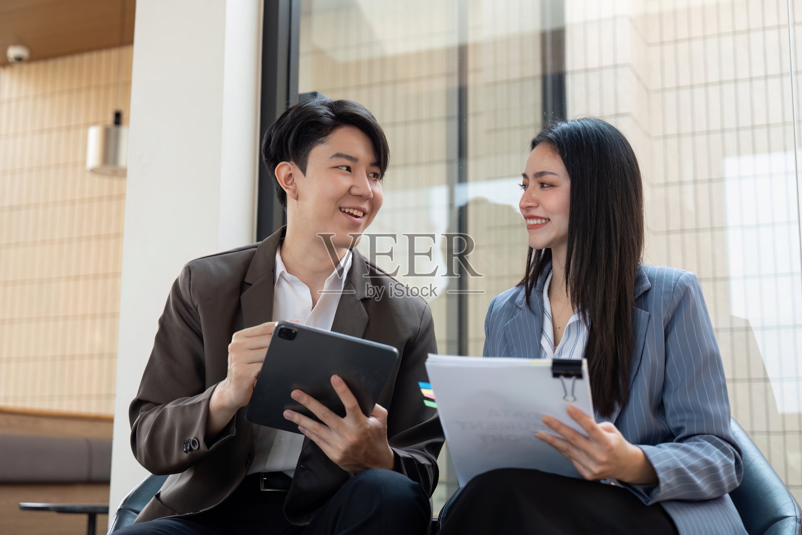 协作规划。专业人士在明亮的办公室中分享见解并审阅材料。照片摄影图片