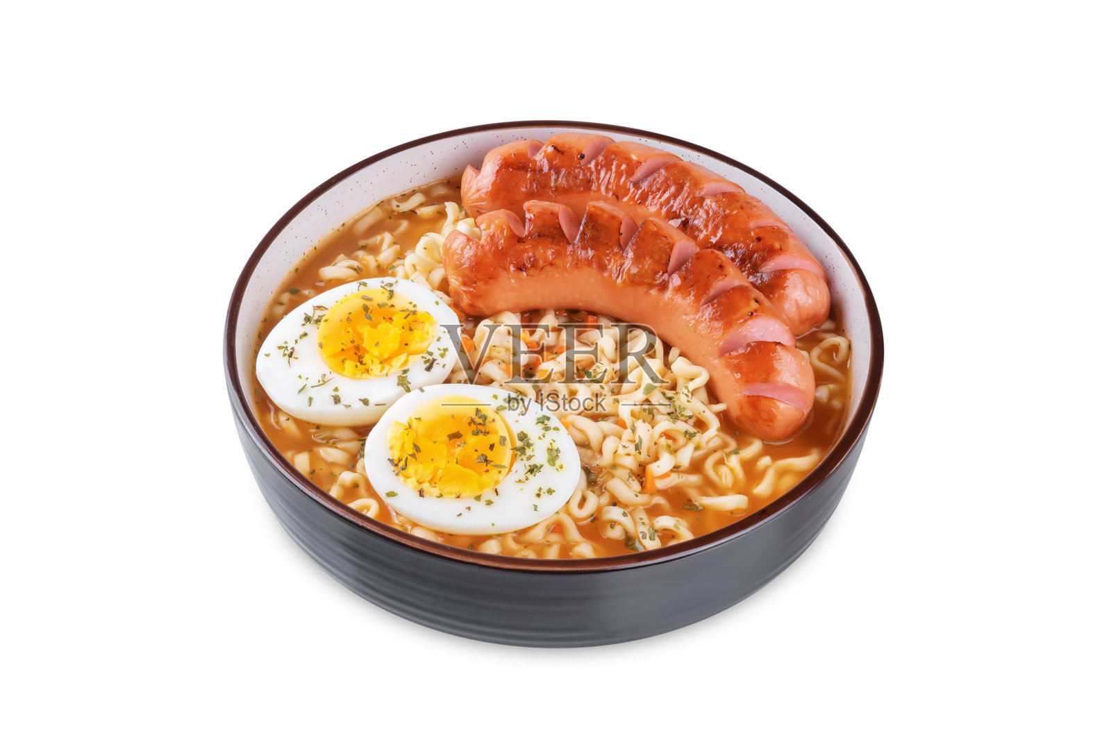 白色背景下的碗中盛有辣味拉面汤，配有炸香肠和鸡蛋。照片摄影图片