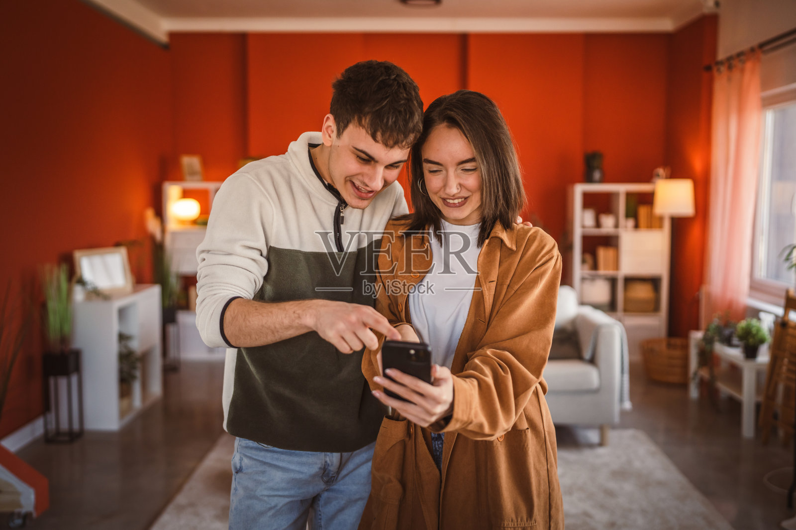 年轻情侣在家里用手机玩乐照片摄影图片