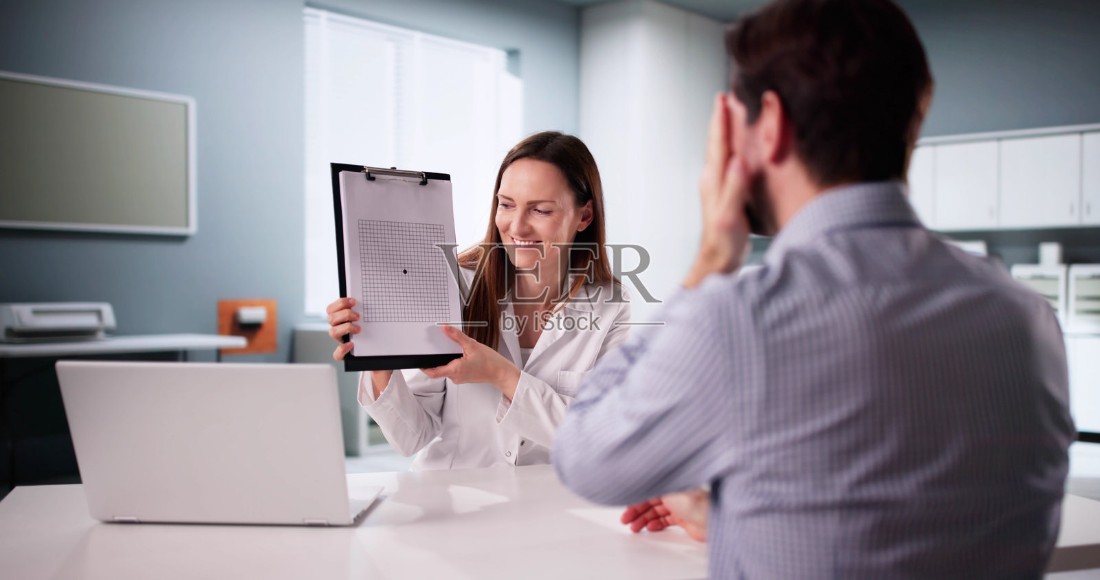 男性医生进行阿姆斯勒网视力检查照片摄影图片