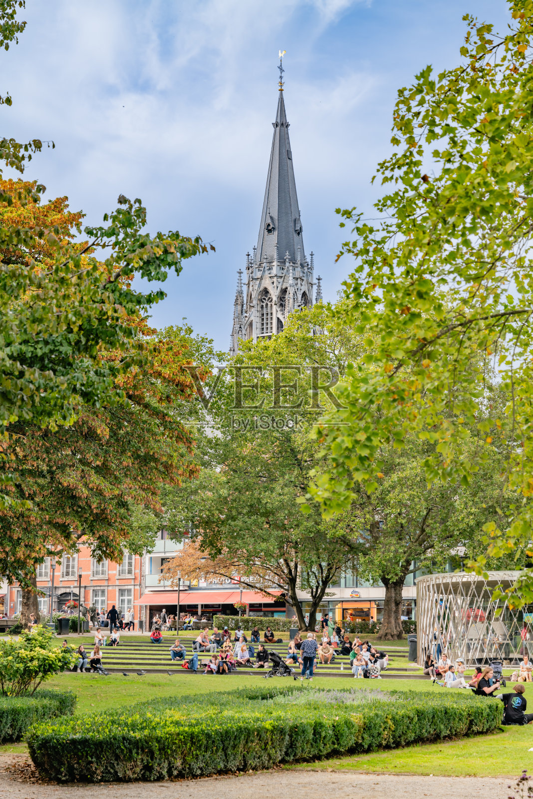亚琛公园的生动场景，标志性的教堂尖塔高耸于绿色田野之上照片摄影图片