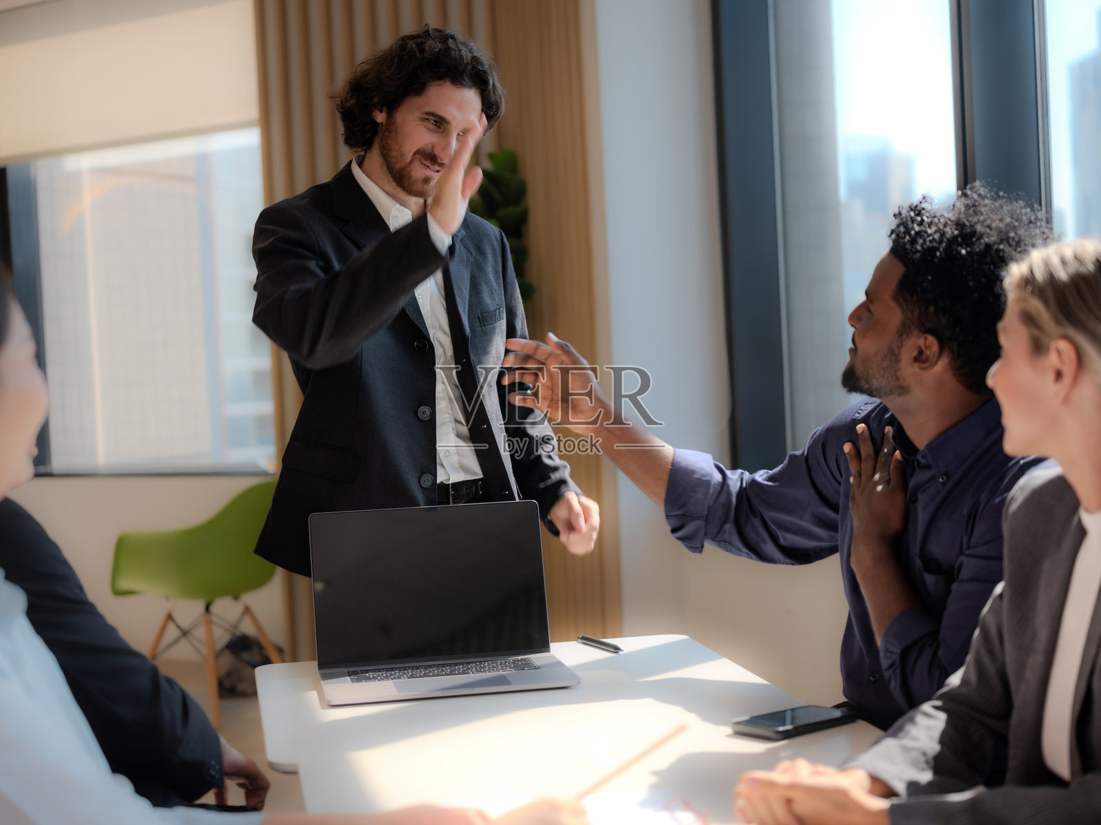 商务团队在会议室讨论战略，击掌庆祝，达成交易，成功。照片摄影图片