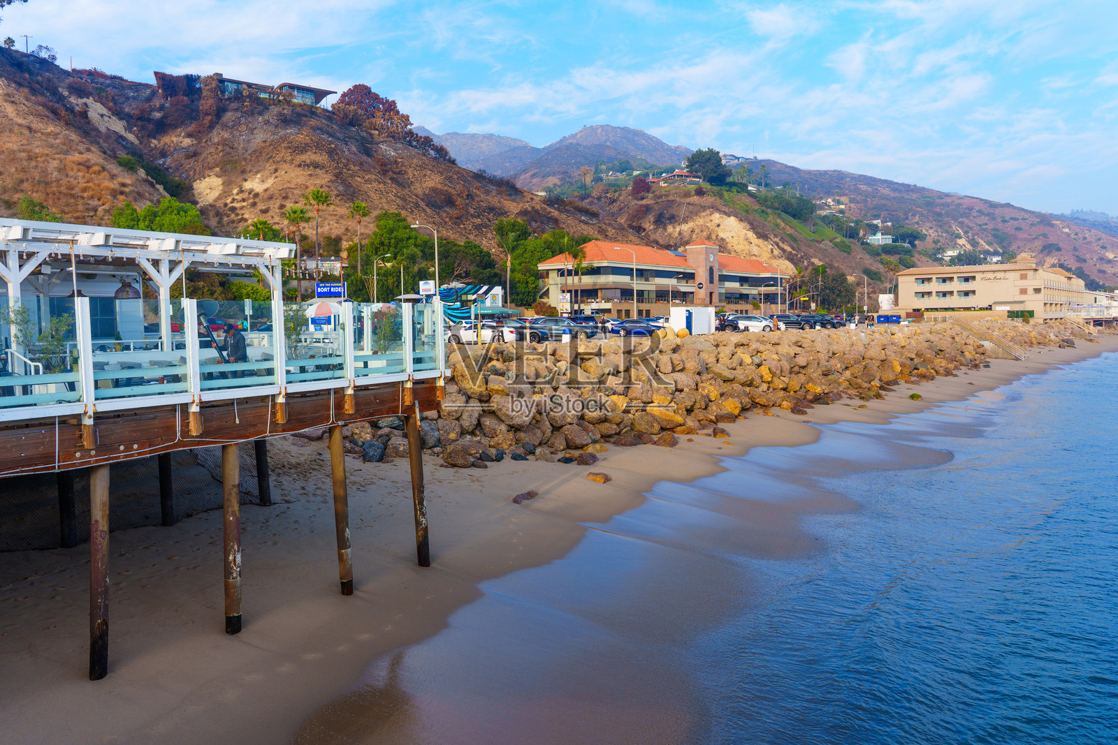 马里布海滩酒店和马里布广场建筑的海洋景观，背景是烧焦的山丘和蓝天照片摄影图片