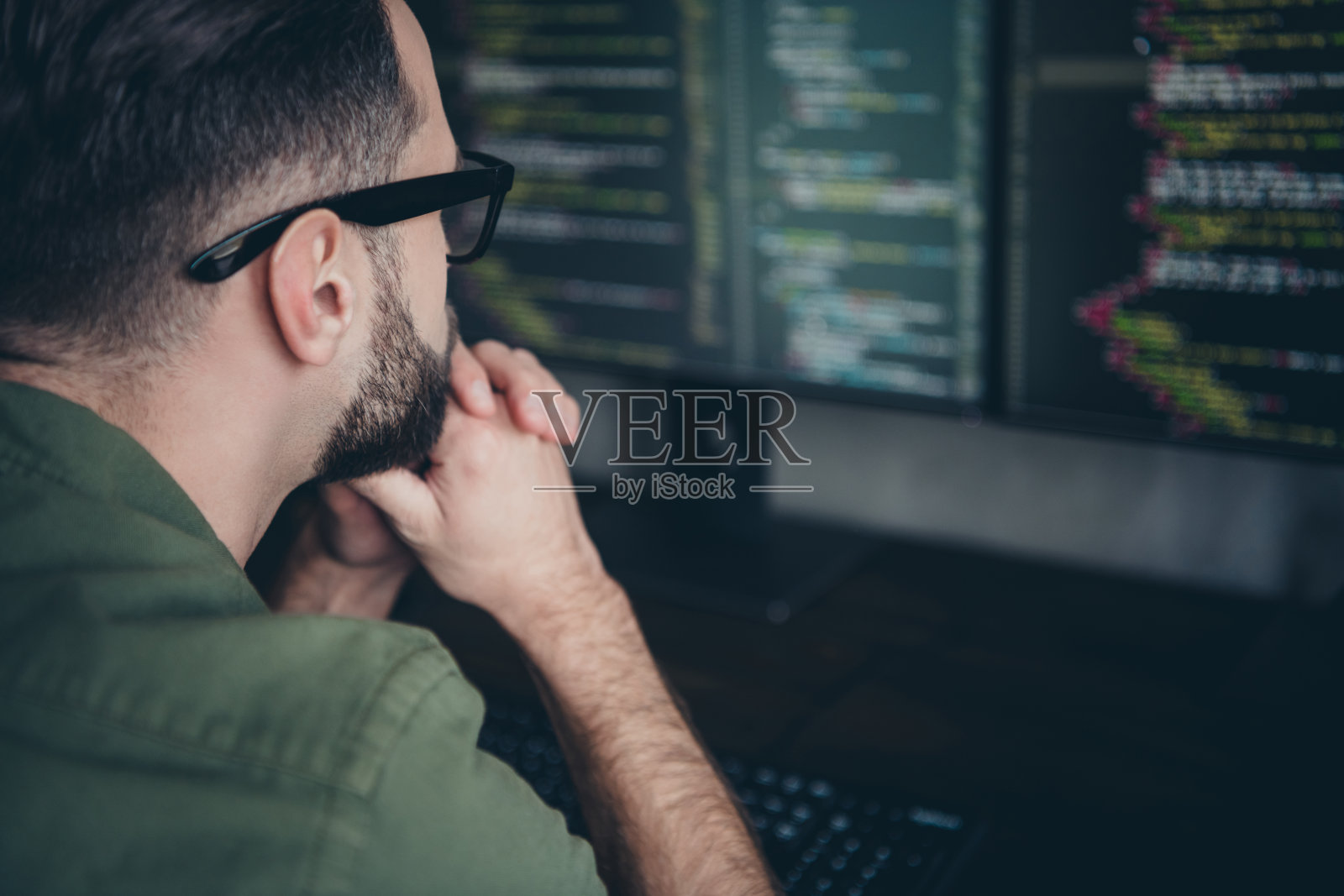 侧面肖像的吸引人、聪明、机智、熟练的男士在室内工作站解决任务的过程照片摄影图片