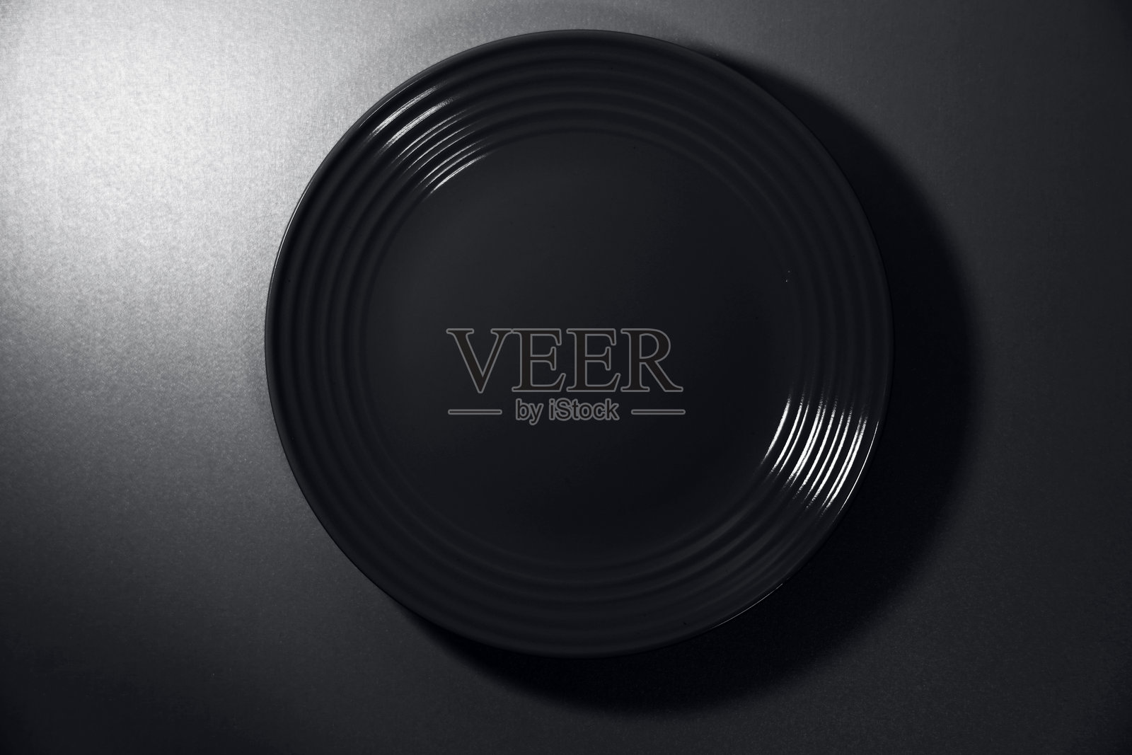 黑色盘子在黑色背景上。照片摄影图片