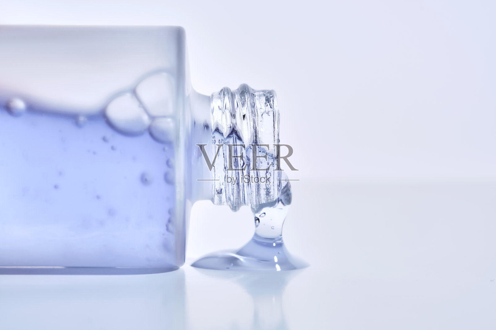 一瓶蓝色乳液的化妆品瓶。照片摄影图片