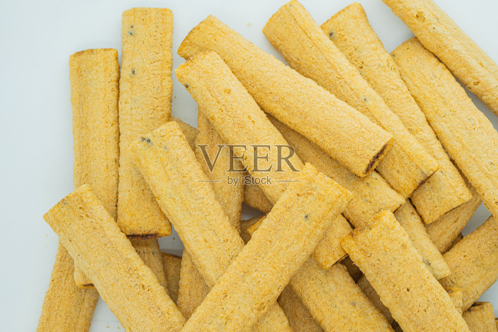 金棕色饼干或椒盐卷饼棒的特写图像，质感丰富且酥脆，棒之间没有缝隙，可能是烘焙或加工而成，中性灰色背景，没有可见品牌。照片摄影图片