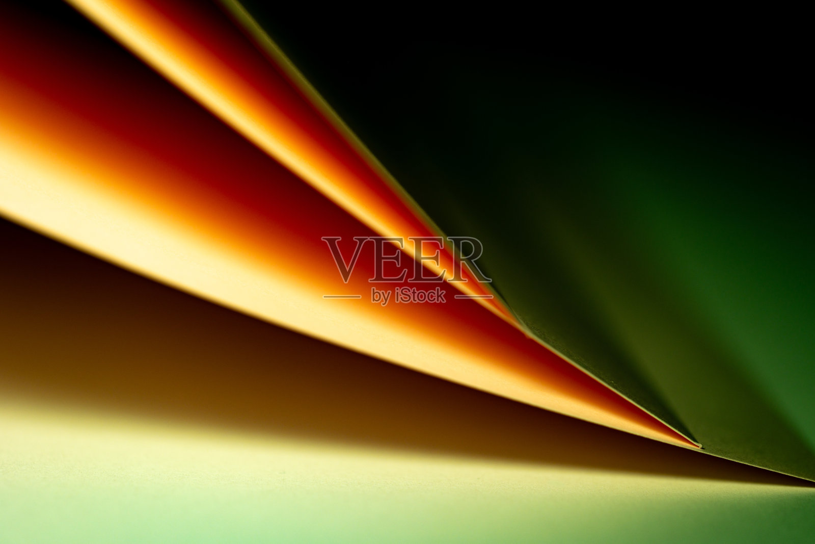 色彩斑斓的抽象曲线，呈现绿色、黄色和橙色的色调以及黑色，营造出动感的视觉体验照片摄影图片