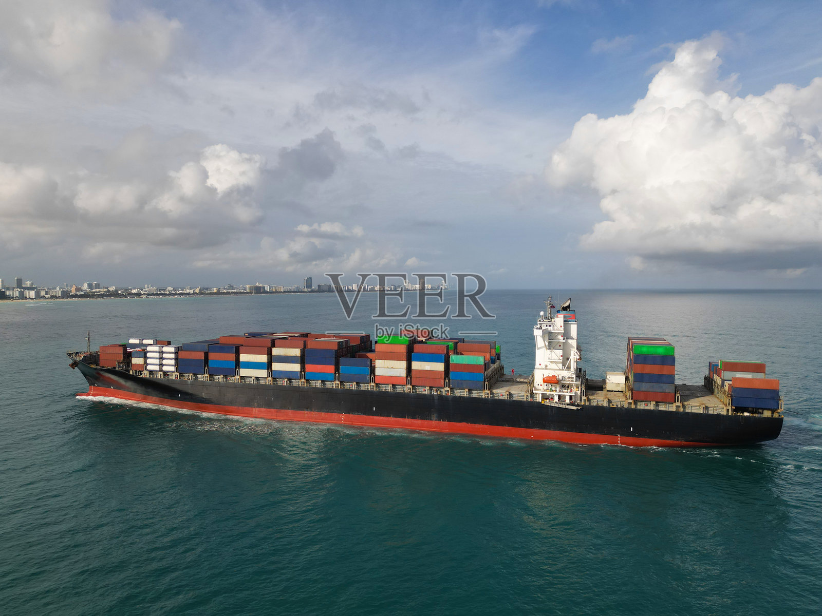 货船进入港口的鸟瞰图。货物运输业务。集装箱船。运输物流。海上货船的鸟瞰图。装载货物的货船。高高堆叠的货运集装箱。照片摄影图片