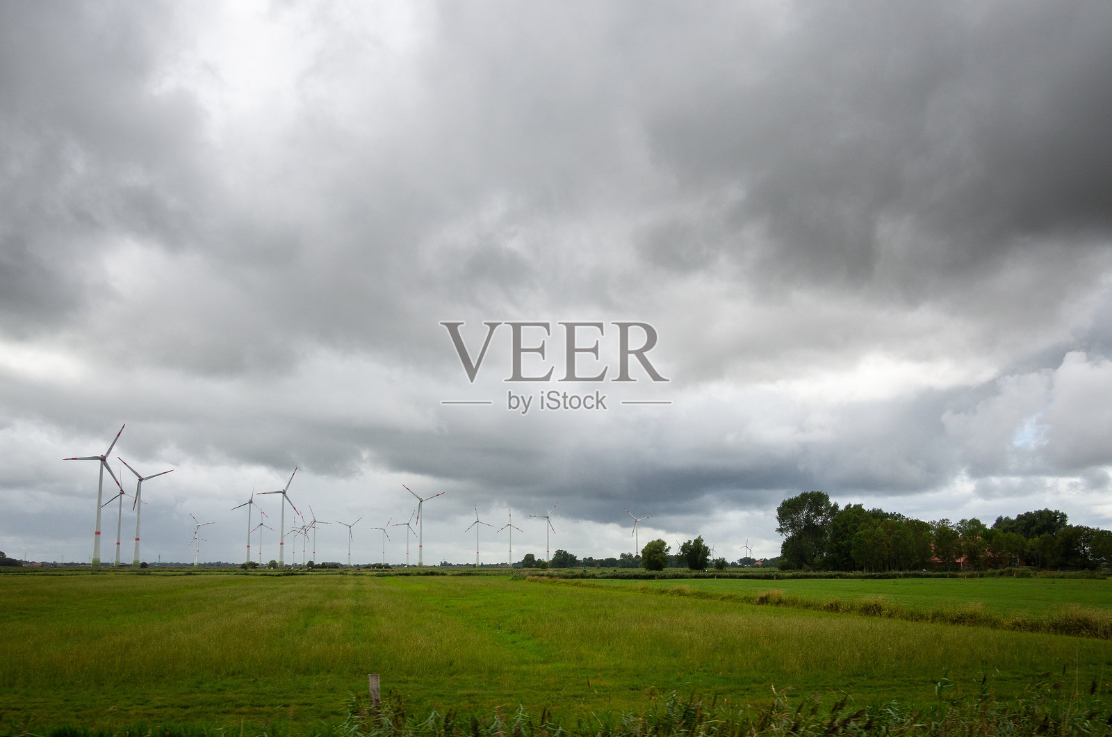 风车下的风景与戏剧性的天空照片摄影图片