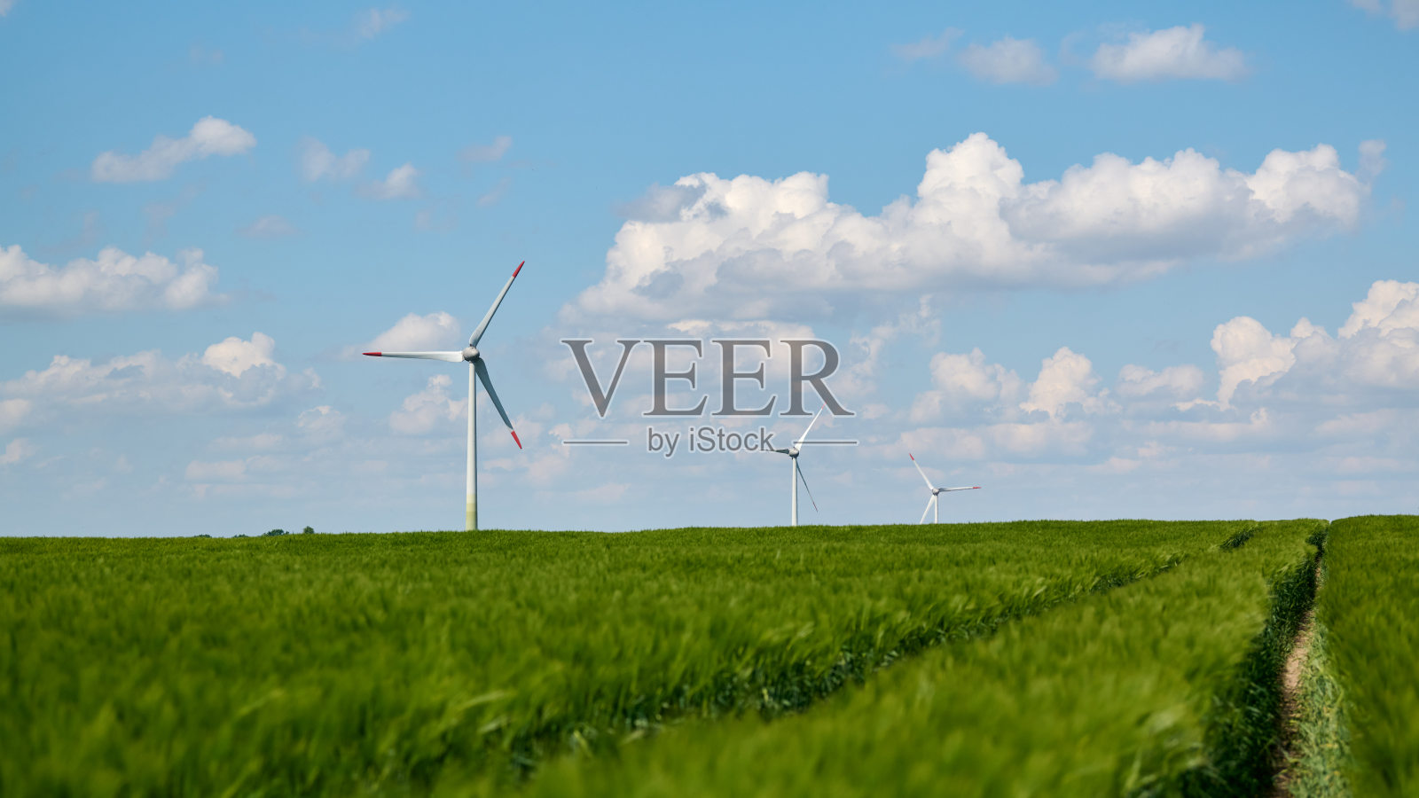 绿色田野下的风力涡轮机与云朵照片摄影图片