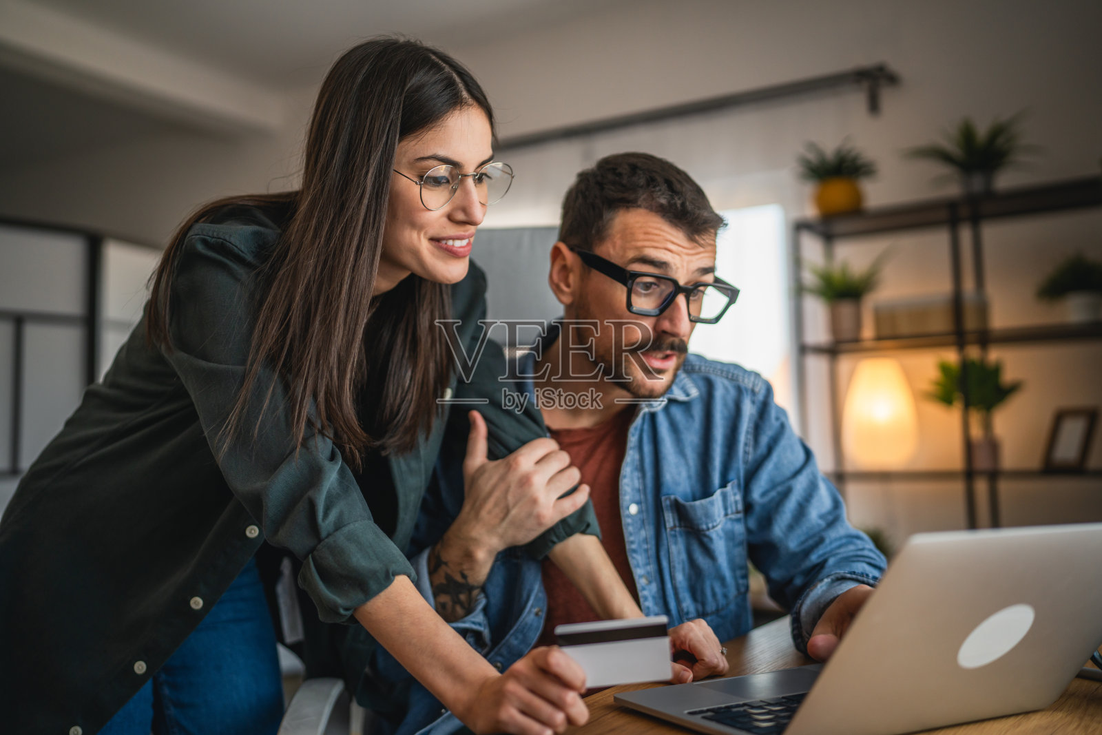 男女在家工作，通过笔记本电脑和信用卡在线购物照片摄影图片