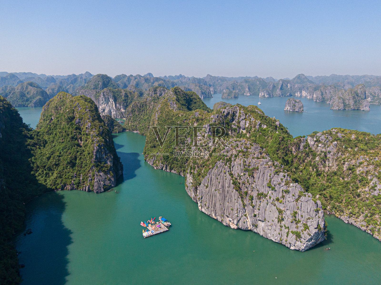 越南下龙湾被石灰岩山峰环绕的漂浮皮划艇平台（无人机视角）照片摄影图片