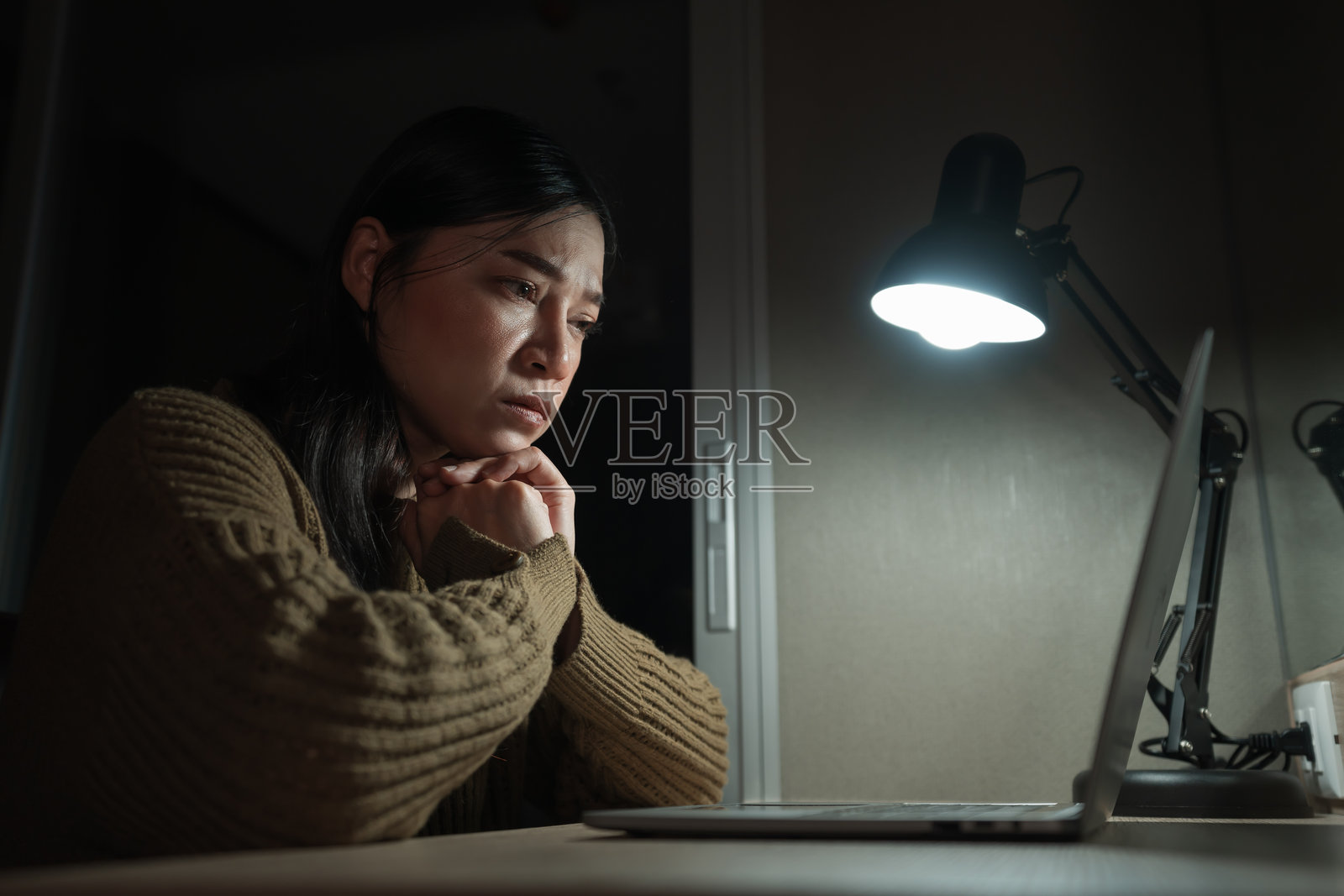 夜晚担心的女性在使用笔记本电脑工作照片摄影图片