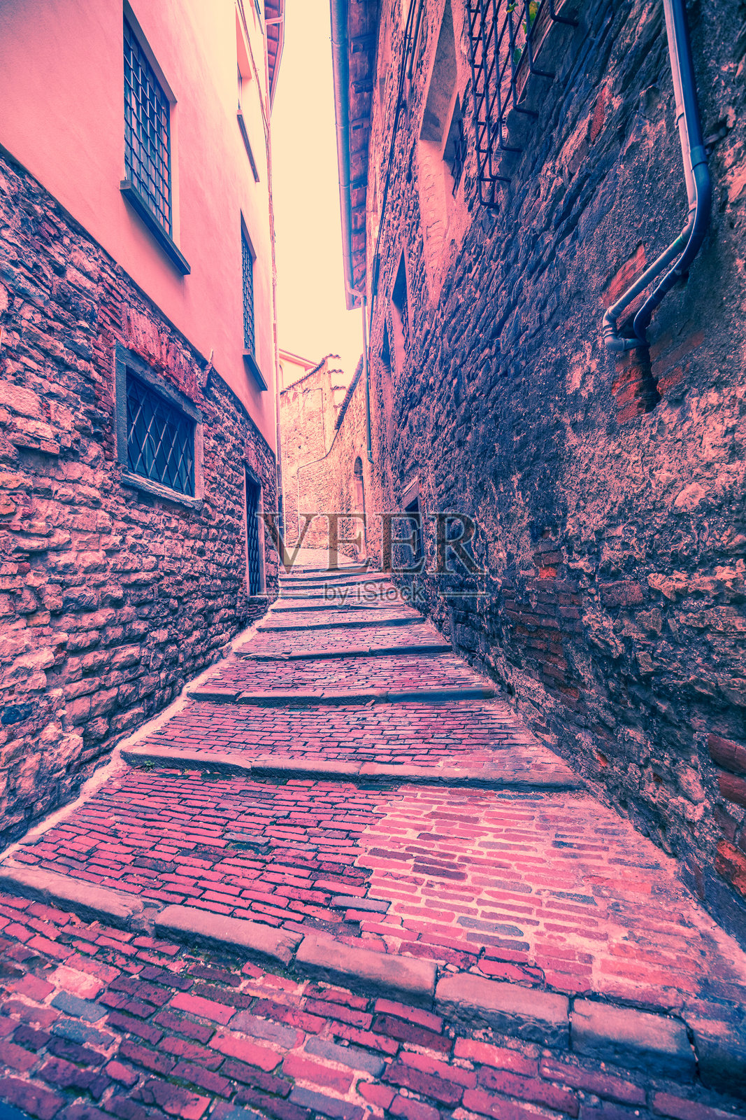 贝尔加莫老城的街道在日落时分。竖幅横幅。酒红色调。照片摄影图片
