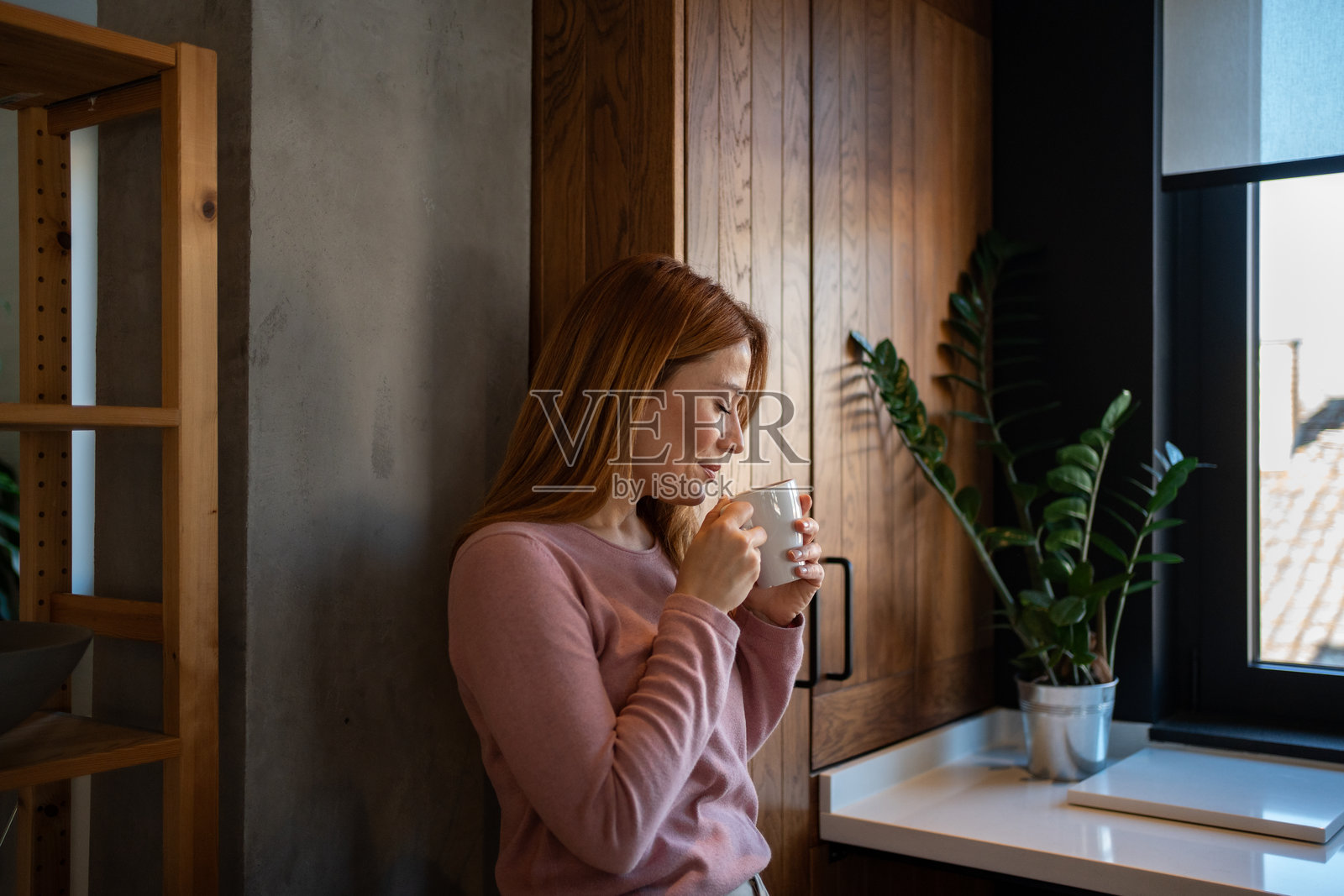 宁静的女性在现代厨房中享受热饮照片摄影图片