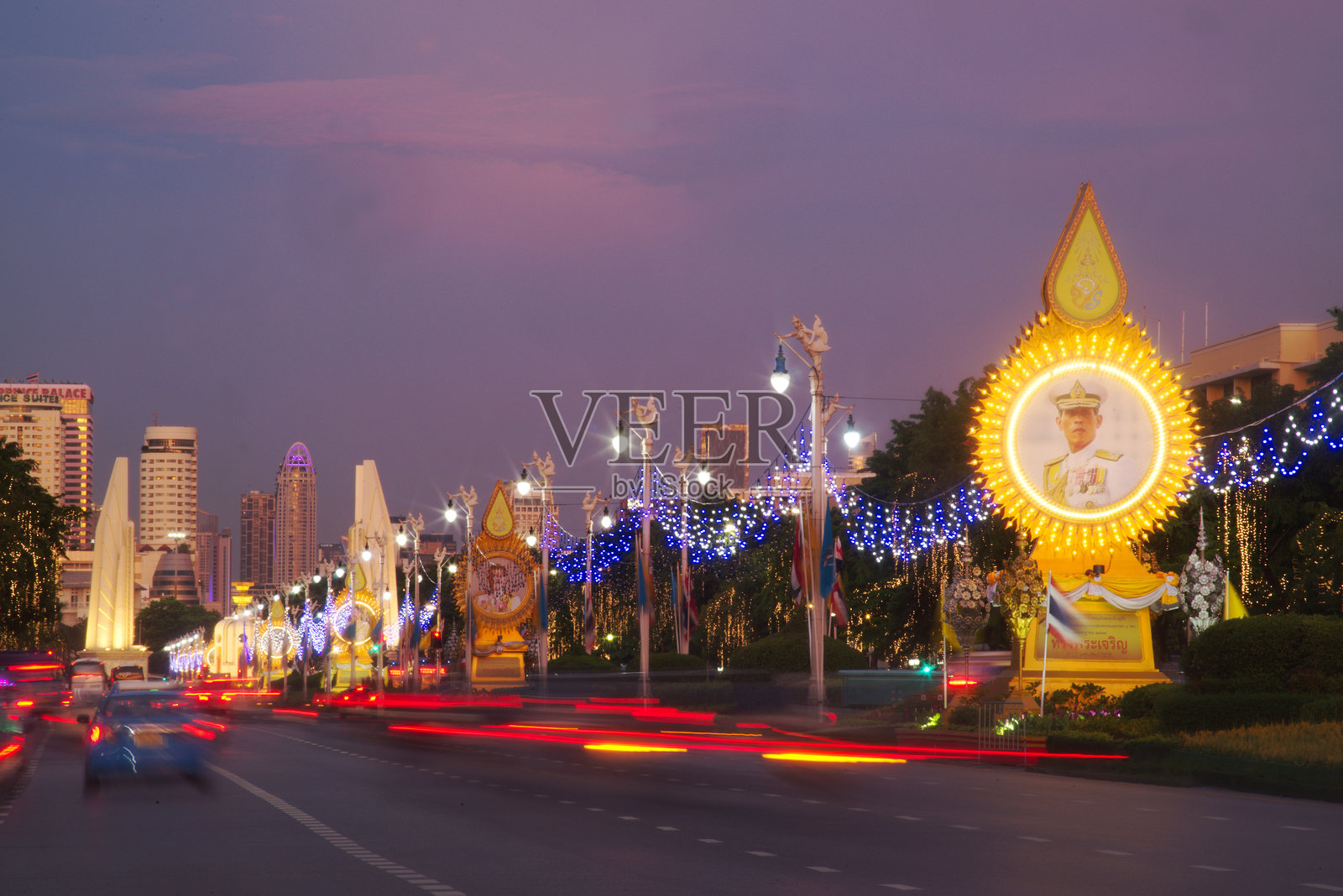曼谷泰国首都拉差达门路的黄昏时分，树木和交通的光影。照片摄影图片