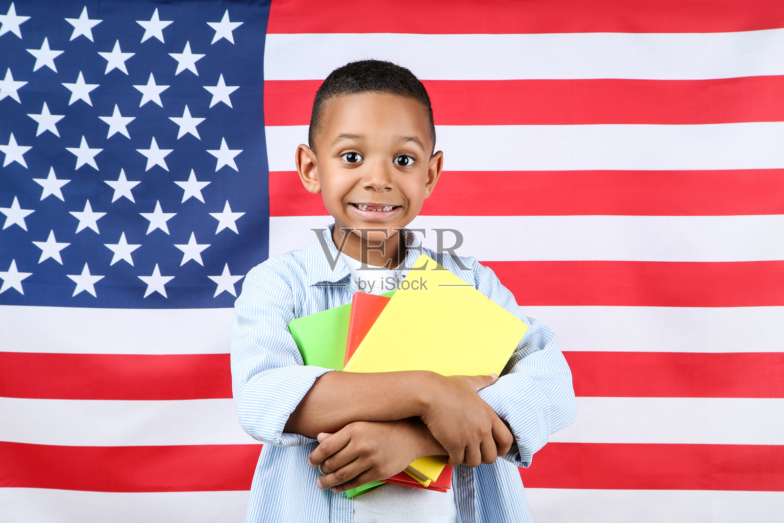 可爱男孩与美国国旗背景下的书籍照片摄影图片