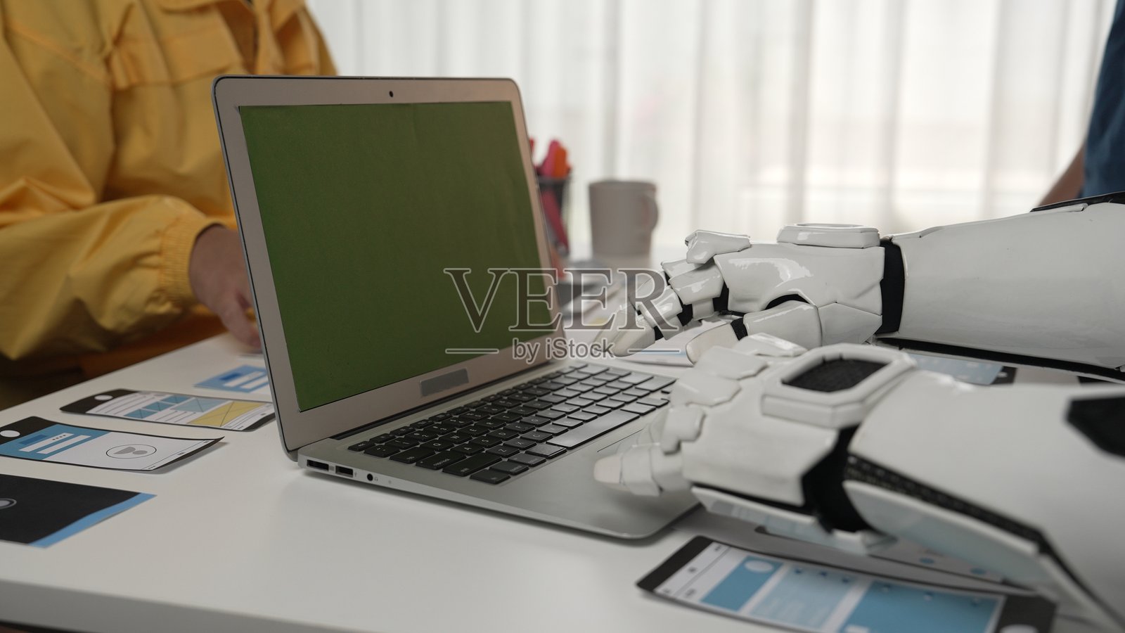 机器人手在现代办公室环境中与笔记本电脑互动照片摄影图片