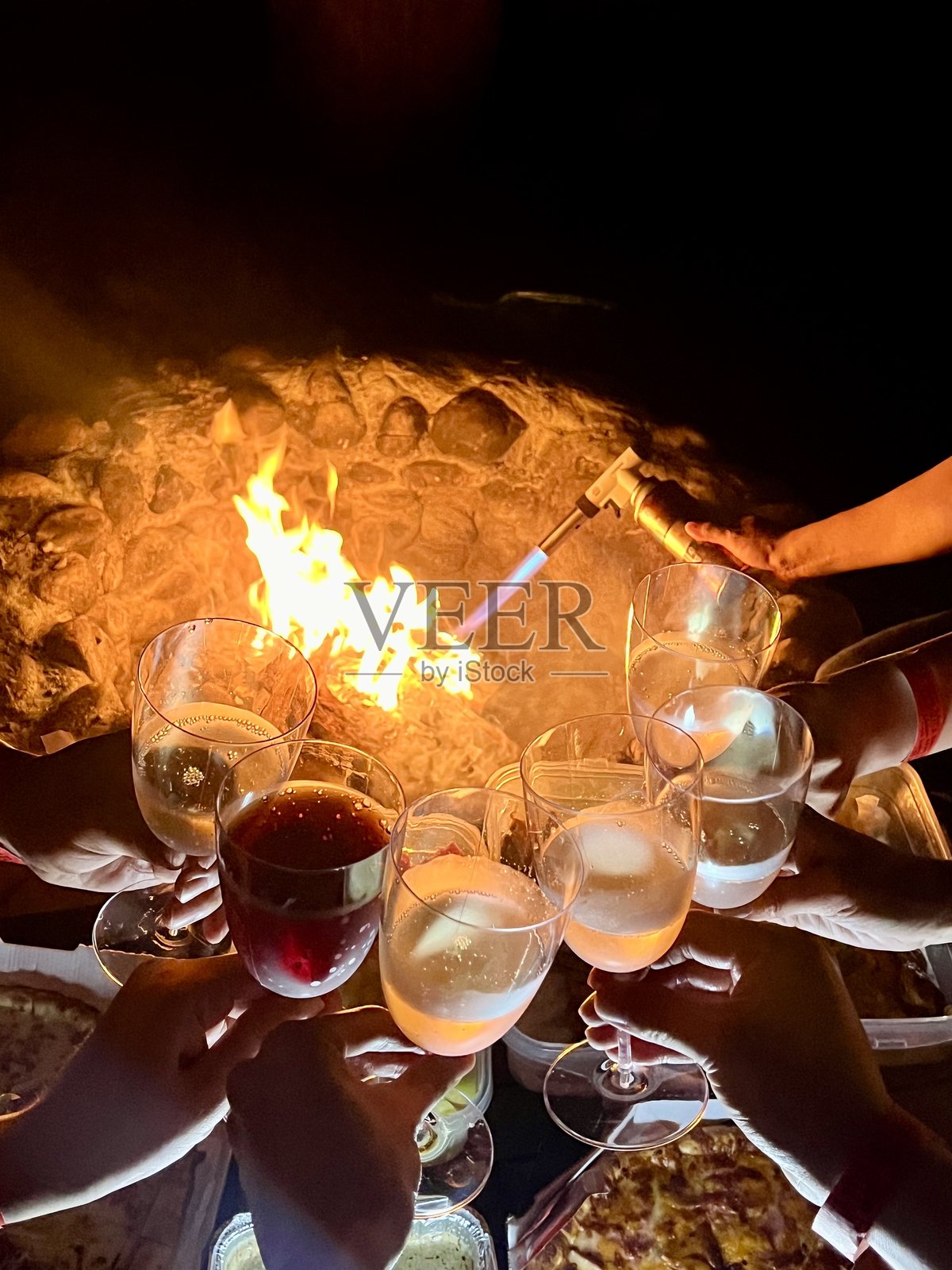 夜晚篝火旁的团体祝酒照片摄影图片