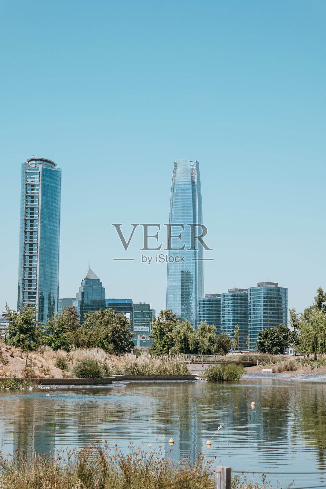 现代摩天大楼在宁静的城市公园中倒影照片摄影图片