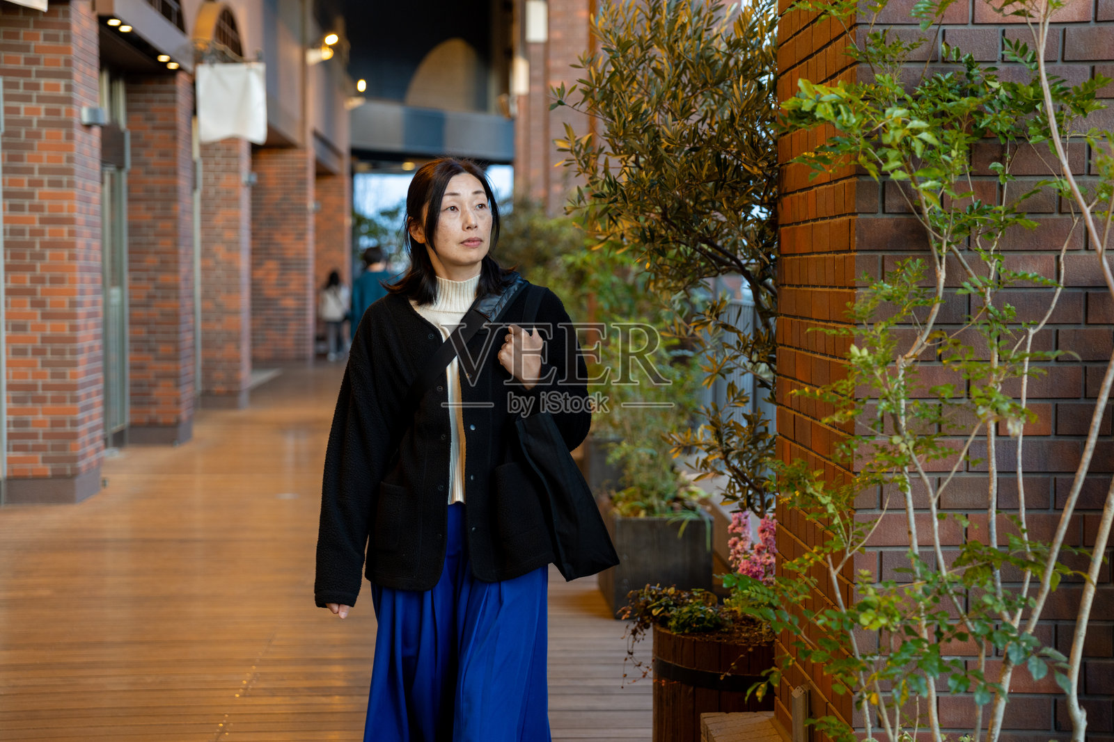 女性在步行道上行走照片摄影图片