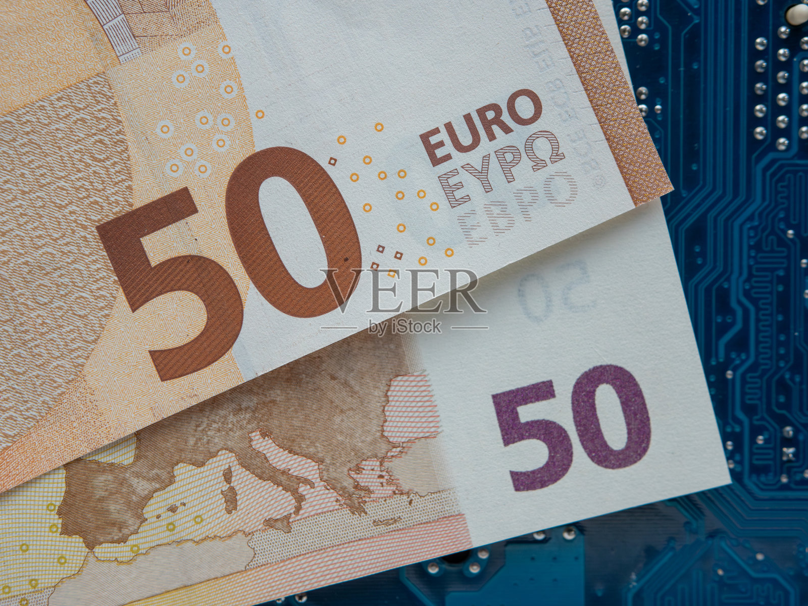 50欧元钞票放在主板上，作为计算机行业融资的概念照片摄影图片