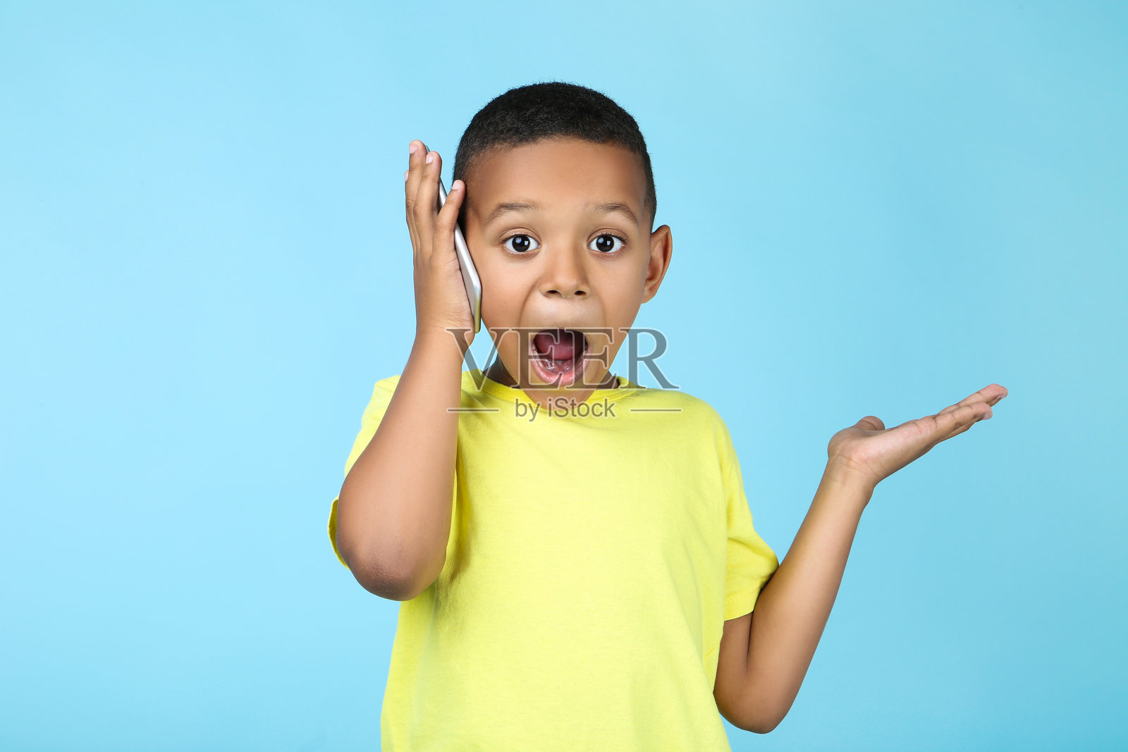 可爱的美国男孩在打手机。照片摄影图片